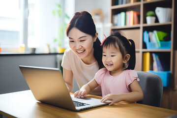 Happy asian mother teaching children learning computer laptop on a online class at home, mother and daughter studying online at home.
