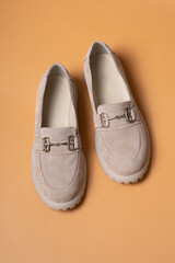 Suede casual woman's shoes on orange background.