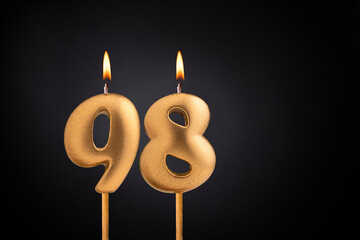 Golden candle 98 with flame - Birthday card on dark luxury background