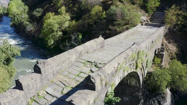 Panoramic aerial shot of medieval Sanahin bridge over Debed river on sunny summer day. Alaverdi, Lori Province, Armenia.