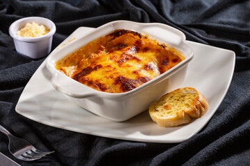 Delicious square hot homemade Italian lasagna - Rustic background