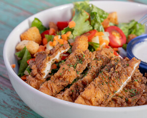 Delicious salad with crispy chicken and dressing, healthy food.