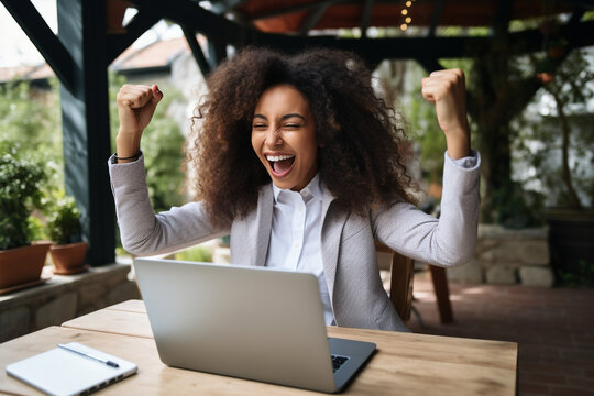 Excited happy african american woman feeling winner rejoicing online win got new job opportunity, overjoyed motivated mixed race girl student receive good test results on laptop celebrating admission