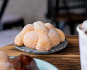 Delicious traditional mexican pan de muerto, with cajeta on top, sugar, inside a coffee, for the day of the dead, mexican culture.