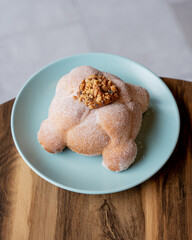 Delicious traditional mexican pan de muerto, with cajeta on top, sugar, inside a coffee, for the day of the dead, mexican culture.