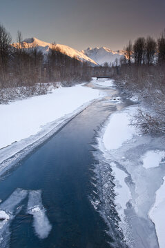 Sunrise View Of Ice Lined Glacier Creek With Light Hitting The Chugach Mountains, Southcentral Alaska, Winter