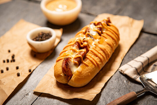 Hot dogs especiales, con pulled pork, bacon, queso fundido, ensalada de col, pepinillo encurtido, cebolla roja, aguacate, ketchup, mayones, salsa picante, coleslaw, sobre pizarra negra y con decoraci&oacute;