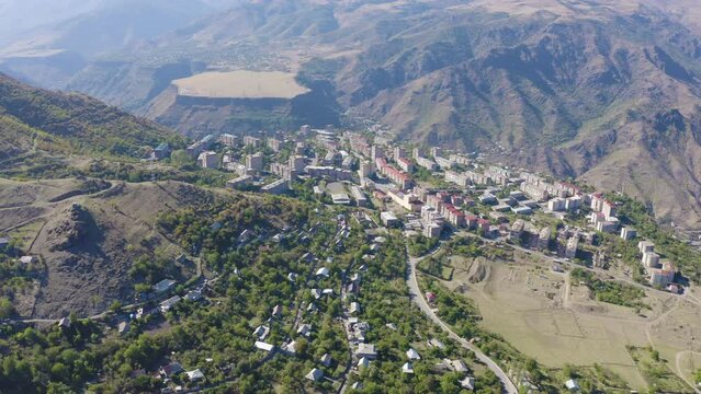 Forward reveal aerial shot of Alaverdi town and Debed river gorge on sunny summer day. Lori Province, Armenia.