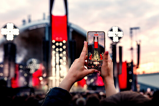 Crowd Enjoying a Summer Outdoor Music Festival and Taking Pictures via Smartphones.