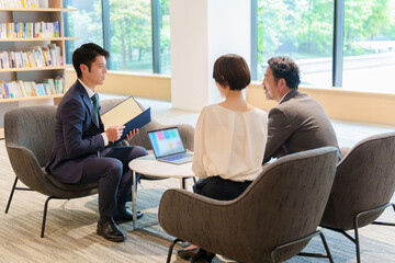 夫婦に説明をする資産運用アドバイザー