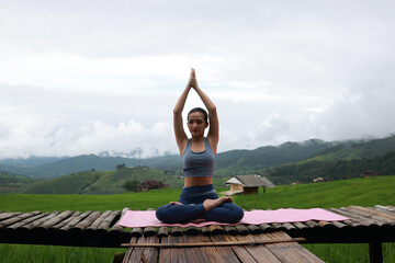 Healthy women exercise Yoga at the green rice terrace field at Mae-Jam Village, Chiangmai