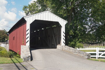 Fototapeta na wymiar Red and White Wood Frame Covered Bridge in Summer
