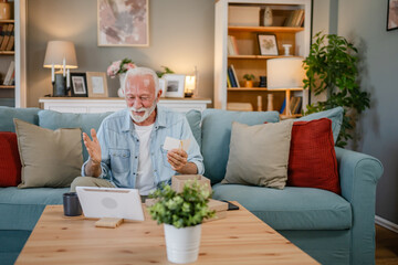 one senior man open box presents and read card while on video call