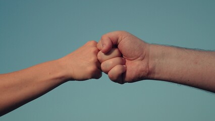 Male and woman fists against sky, trust, harmony, friendship. Fist to fist sign, expresses consent, gesture of respect. Teamwork concept. Lifestyle business team clenching their fists, Hands closeup