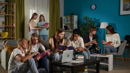 Medium shot of a group of teens, young people, friends studying, preparing for an exam, discussing, looking at their notes, using devices, watching something.