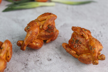 Fried juicy tasty grilled chickens on a gray background. Polymer clay. Food for dolls. Background for the cook.