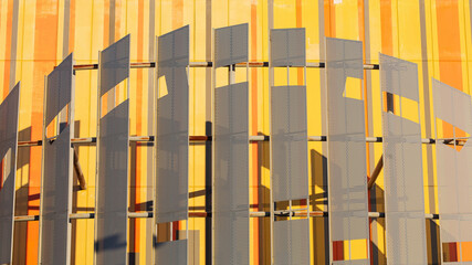 The concrete building is painted in yellow pattern and is equipped with decorative metal plates.