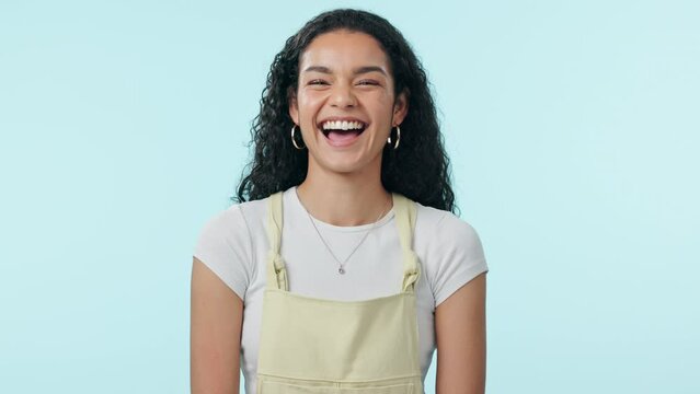 Comic, laugh and face of woman in studio with funny, joke or goofy humor on blue background space. Comedy, happy and female model portrait with laughing reaction to crazy comment or feel good mood