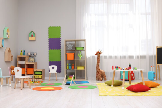 Child`s playroom with different toys and furniture. Cozy kindergarten interior