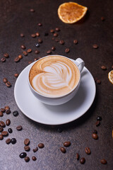 Cappuccino and coffee beans on a dark table