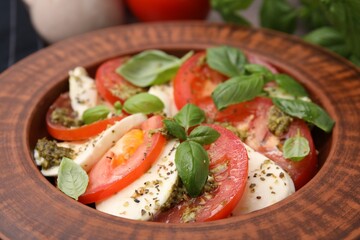 Delicious Caprese salad with pesto sauce in plate, closeup
