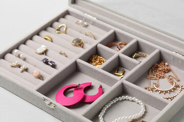 Jewelry box with many different accessories on light background, closeup