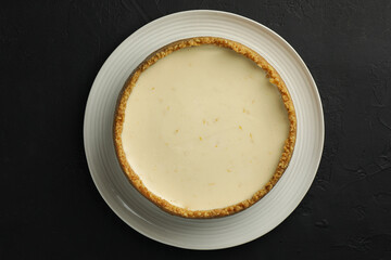 Tasty vegan tofu cheesecake on black table, top view