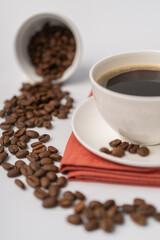 Seeds of coffee spread around a coffee cup