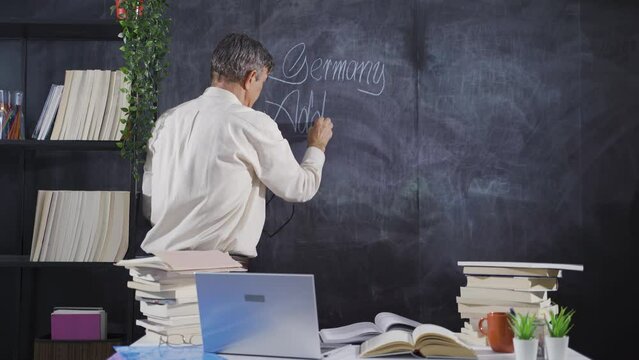 The historian man writing Adolf Hitler on the blackboard.