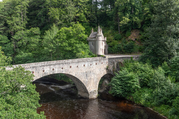 The stone Bridge of Avon over the Avon river with its picturesque gatehouse. Near Ballindalloch, Moray, Scotland, United Kingdom, and built between 1800 and 1801.  - obrazy, fototapety, plakaty