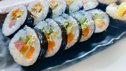 Close up of a gimbap served in a black long plate, a popular traditional authentic South Korean dish