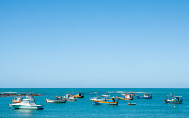 beach with boats in the sea with blue sky and space for text
