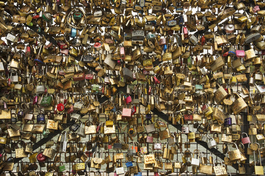 A Multitude Of Padlocks Tied To A Bridge Forming A Pattern Of Shiny Objects; Paris, France