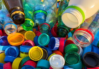 Plastic Recycling. Water bottles and plastic Bottle Caps for Recycling. Plastic recyclable and Reinventing. Bottle caps for Recycling. Lids from Plastic Bottles for Reuse. Plastics Reduce. Biopalstic - obrazy, fototapety, plakaty