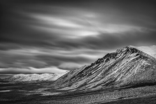 Black And White Long Exposure Of Clouds Over The Cloudy Range Along The Dempster Highway; Yukon, Canada
