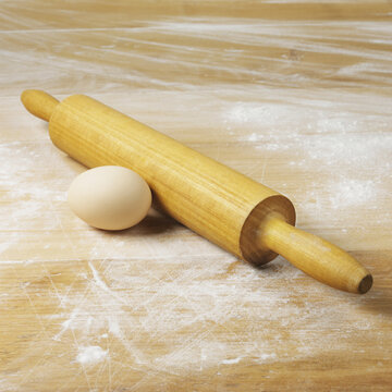 An Egg And Rolling Pin On A Floured Surface; Toronto, Ontario, Canada