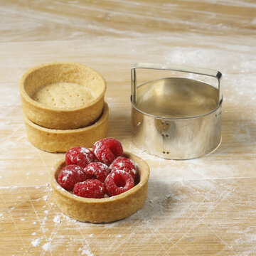 Dessert Cups On A Floured Surface With Raspberries In One, And A Round Cookie Cutter; Toronto, Ontario, Canada
