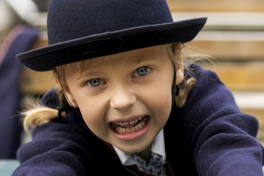 Portrait Of A Young Girl Wearing Blue Sweater And Felt Hat Looking Into The Camera; London, England