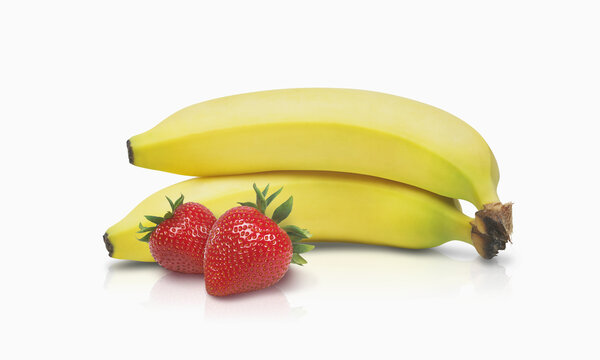 Two Bananas And Two Strawberries On A White Background; Toronto, Ontario, Canada