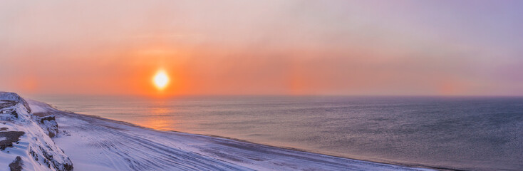 Sunset through windblown snow creates a sundog above the Beaufort Sea along the coast just outside of Barrow, Winter, Arctic Alaska, USA.