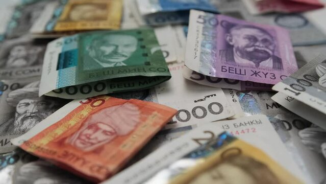 Paper bills pack Kyrgyz som different value on table close up. Many cash som fresh printed money of Kyrgyzstan tracking shot background. Trading exchange.