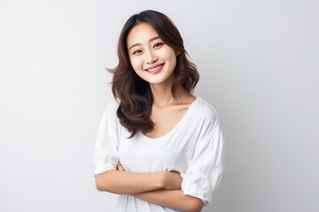 Portrait of an Asian woman with white wall background.