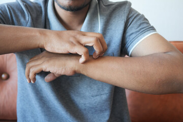 man suffering from itching skin, close up.