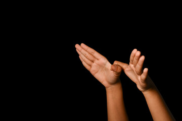 Hands making a gesture of bird or dove as a freedom symbol on black background