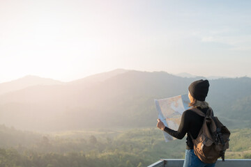 Adventurous girl navigating in with a topographic map in beautiful mountains of thailand. woman wearing hat stand alone and enjoying freedom and calm inspired travelling on background view mockup.