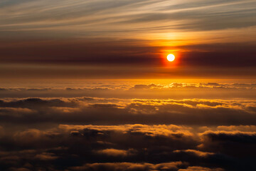 Naklejka na ściany i meble The beautiful view of the sun rising above the sea of ​​clouds is so exotic and full of magic