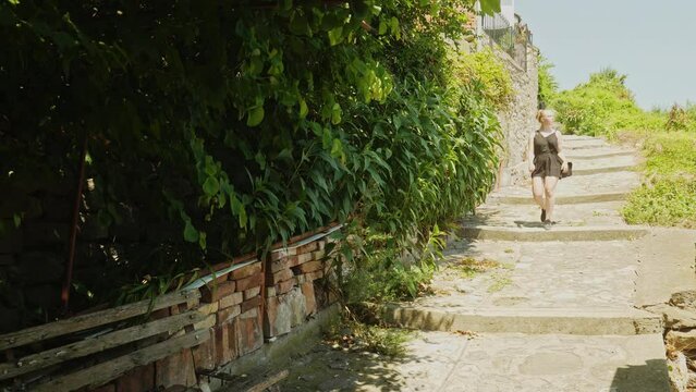 Female travel tourist explorers historic Veliko Tarnovo on hot sunny day