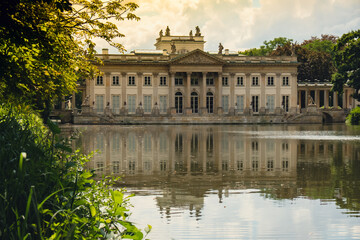 Fototapeta na wymiar Baths classicist Palace on the Isle in Lazienki Park touristic place in Warsaw. Lazienki Royal Baths Park, Warsaw Poland. Mirror Reflection on the Lake. Nature in summer Baroque columns 