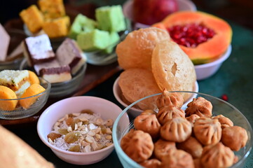 Traditional Indian Sweets. Maharashtra Sweets for hindu festival celebration. Greetings with a Barfi set, Modak, sweets in a bowl. Fruits.  Happy festivals. Navratri. Dussehra. Happy Diwali