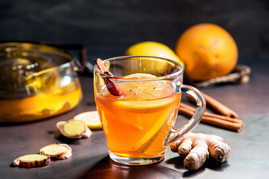 A relaxing and delicious glass cup with tea, lemon, cinnamon, cloves and ginger.